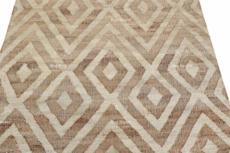 May include: Close-up of a beige and brown geometric patterned rug. The rug features a repeating diamond and zig-zag design. The rug is made of a woven material and has a textured appearance. The rug is suitable for home decor.