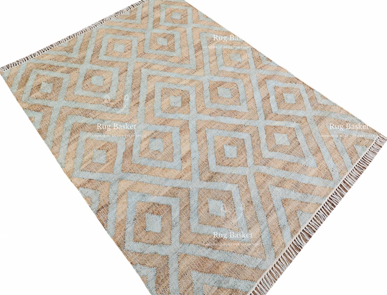 Pu&ograve; includere: Un tappeto rettangolare con un motivo geometrico a rombi in marrone chiaro e azzurro. Il tappeto ha un bordo sfrangiato ed &egrave; realizzato in materiale tessuto. Il design &egrave; simmetrico e moderno, adatto all'arredamento della casa.