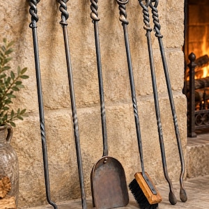 May include: A set of five dark metal fireplace tools featuring twisted handles and looped ends. The collection includes a poker, a scraper, a shovel, a brush with wooden block and black bristles, and a pair of tongs with a hinged top mechanism.