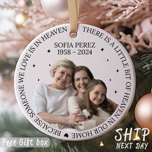 May include: White ceramic ornament with a photo of three women and the text "Because someone we love is in heaven. There is a little bit of heaven in our home."  The text also includes "Sofia Perez 1958-2024".