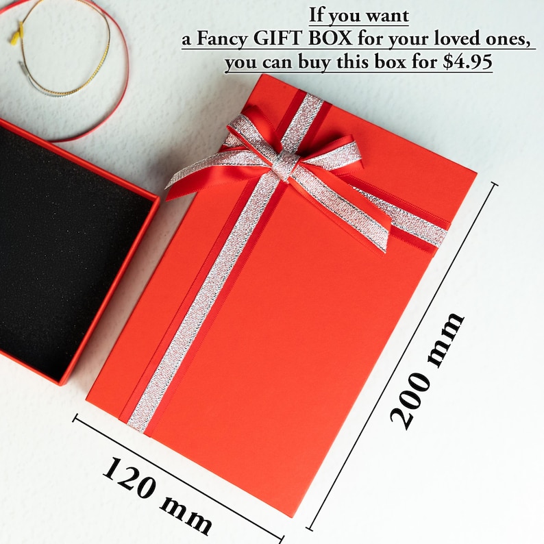 a red gift box with a ribbon and a pair of glasses