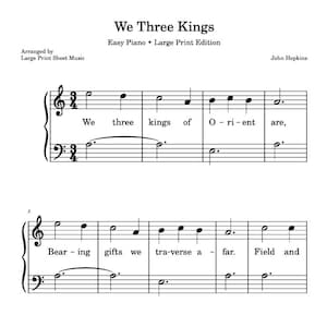 以下が含まれることがあります： 「We Three Kings」の楽譜、大判印刷版。タイトルは上部にあり、作曲者の名前と編曲者の情報が記載されています。楽譜にはト音記号とヘ音記号が含まれており、音符の下に歌詞が書かれています。