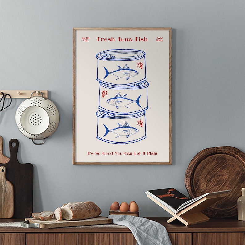 May include: A framed print featuring a stack of three blue and white tuna fish cans. The text "Fresh Tuna Fish" and "It's So Good You Can Eat It Plain" are printed in red. The net weight is 7 oz.