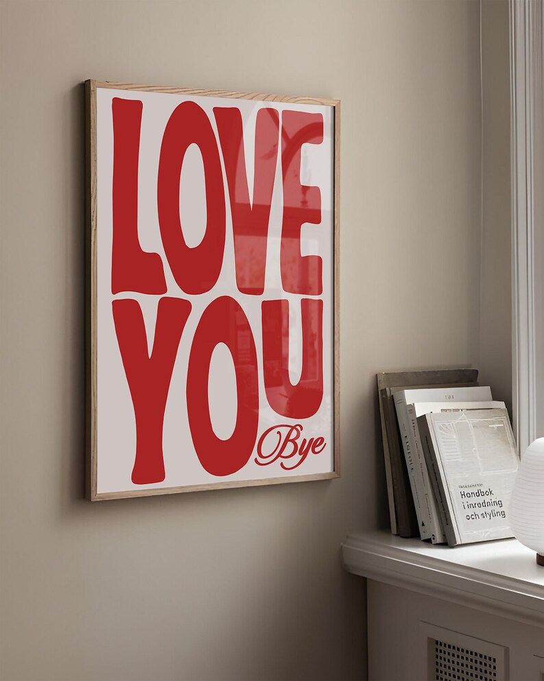 K&ouml;nnte beinhalten: Ein gerahmtes Poster mit den Worten "LOVE YOU" in gro&szlig;en, roten, fetten Buchstaben. Das Wort "Bye" ist darunter in Kursivschrift geschrieben.