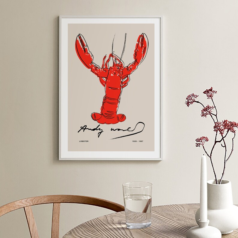 May include: A red lobster illustration with black outlines on a beige background. The illustration is signed "Andy Warhol" with the text "Lobster 1928 - 1987" below the signature.