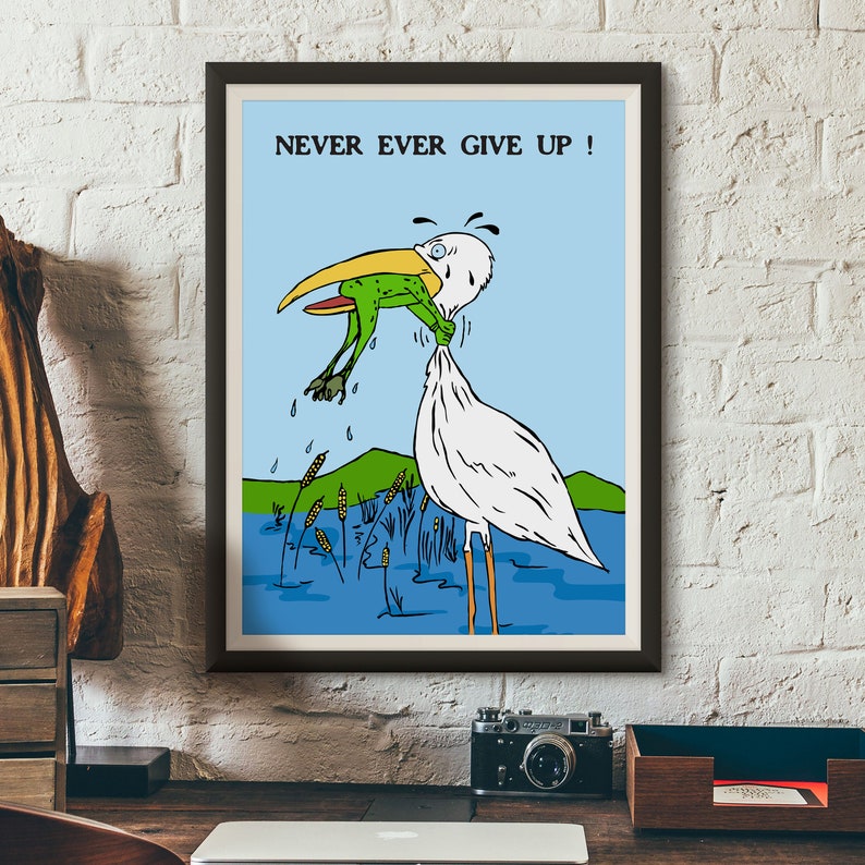 May include: A framed cartoon illustration of a white bird with a long beak holding a green frog in its beak. The bird is standing in a blue pond with green reeds. The text "NEVER EVER GIVE UP!" is printed in black at the top of the image.