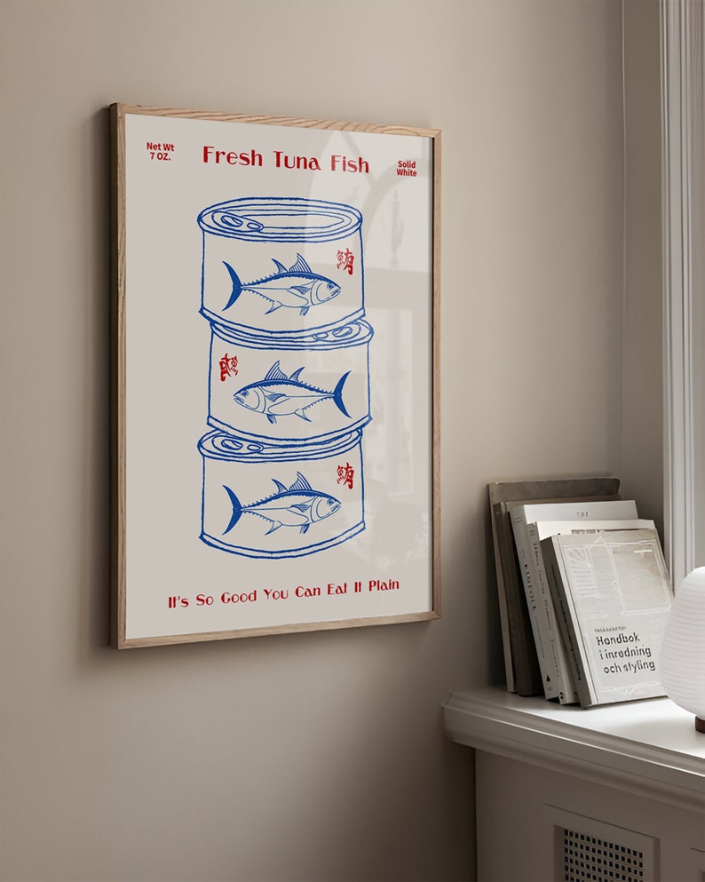 May include: A framed print featuring a stack of three blue and white tuna cans. The words "Fresh Tuna Fish" and "It's So Good You Can Eat It Plain" are printed in red. The net weight is 7 oz.