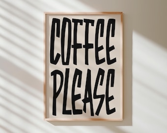May include: A framed print with the words "COFFEE PLEASE" in bold, black, handwritten-style letters. The background is a light beige color, and the frame is a light brown wood. The print is displayed on a white wall.