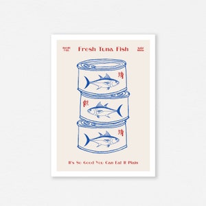 May include: A print featuring three stacked tuna fish cans in blue and white. Each can has a tuna fish illustration and Chinese characters. The text "Fresh Tuna Fish" and "It's So Good You Can Eat It Plain" are also included.