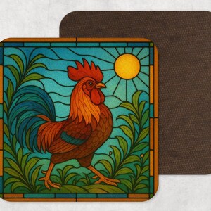 May include: Square coaster with a vibrant rooster design, reminiscent of stained glass. The rooster has red, orange, and brown plumage, set against a blue sky and green leaves. A second, plain brown coaster is next to it.