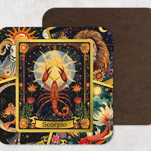 May include: Square coaster with a detailed zodiac design featuring a scorpion illustration, surrounded by celestial and floral elements. The coaster has a dark background with gold accents and a brown leather-like backing.
