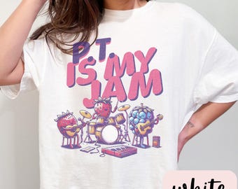 May include: White t-shirt with a pink and purple graphic of fruit playing instruments. The text "PT is my JAM" is printed on the shirt.
