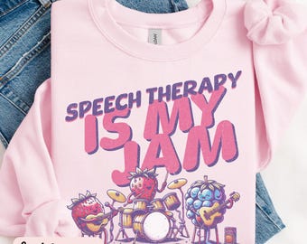 May include: Light pink sweatshirt with the text "Speech Therapy is My Jam" in purple and pink lettering. The text is surrounded by a cartoon illustration of a strawberry, blueberry, and raspberry playing musical instruments.