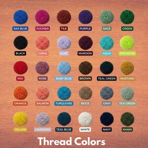 May include: A color chart of thread colors, featuring a grid of yarn pom-poms in various shades. Each pom-pom is labeled with its corresponding color name, such as "Sax Blue," "Fuchsia," and "Teal Green." The text "Thread Colors" is at the bottom.