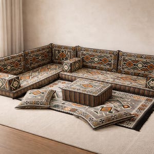 Peut inclure: Un ensemble de sièges bas modulables avec des coussins à motifs et un tapis assorti. Les coussins présentent des motifs géométriques dans des tons de marron, d'orange et de vert. Le tapis a une frange noire.