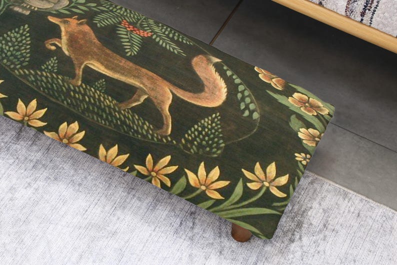 Op de afbeelding: Houten bank met een donkergroen oppervlak met een vosillustratie. De vos is bruin en bruin, omringd door groene bladeren en gele bloemen. De bank heeft een bloemenrand en houten poten.