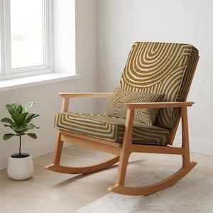 May include: A wooden rocking chair with a mustard cushion and pillow, patterned with white curved lines. The chair has a light wood frame and armrests. A small potted plant sits near a window.