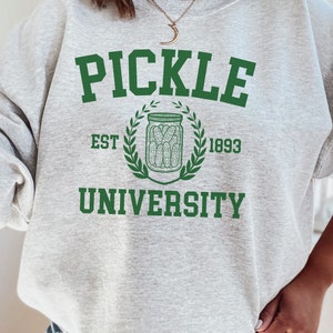 May include: Grey sweatshirt with green text that reads "Pickle University" with a green wreath and a jar of pickles inside. The text "Est 1893" is below the wreath.