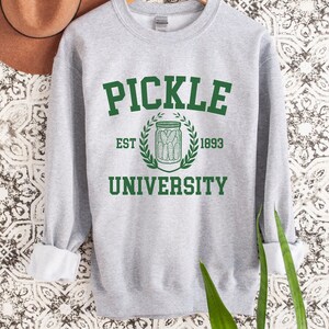 May include: A grey sweatshirt with a green print that says "Pickle University" with an illustration of a jar of pickles and the text "Est. 1893".