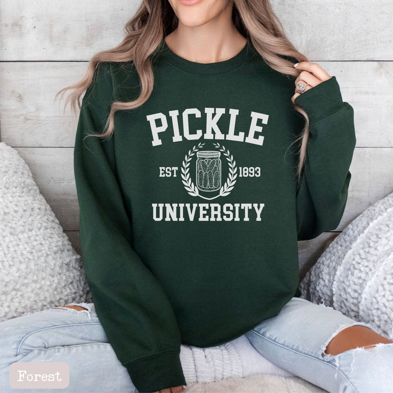 May include: A dark green sweatshirt with white text that reads "Pickle University" with a pickle jar graphic and the text "Est. 1893".