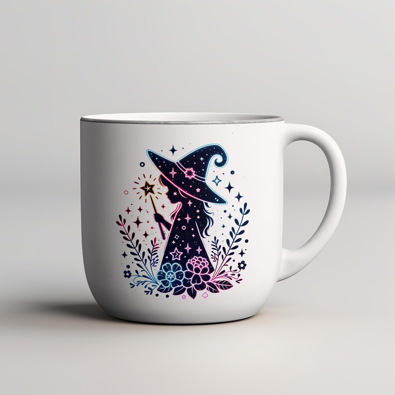 May include: White ceramic mug featuring a silhouette of a witch with a hat and wand, surrounded by floral and star designs. The witch and surrounding elements are in shades of blue, pink, and purple. The mug has a silver rim and a curved handle.