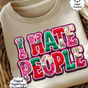 Könnte beinhalten: Beiges Sweatshirt mit dem Schriftzug "I HATE PEOPLE" in einem farbenfrohen, floralen Design. Die Buchstaben sind pink und grün umrandet, mit Totenkopf- und gekreuzten Knochen-Akzenten. Es ist ein digitaler Download.