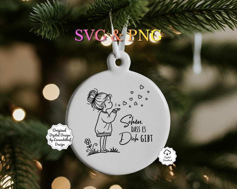Puede incluir: Un adorno navide&ntilde;o de cer&aacute;mica blanca con una ilustraci&oacute;n en blanco y negro de una ni&ntilde;a soplando burbujas en forma de coraz&oacute;n. El adorno tiene el texto "Sch&ouml;n, dass es Dich gibt". Cuelga de una cinta blanca.