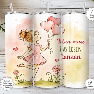 May include: A white tumbler with a whimsical design featuring a girl holding heart-shaped balloons. The girl is wearing a pink dress and the tumbler has the German text "Man muss DAS LEBEN tanzen". Includes a straw and decorative elements.