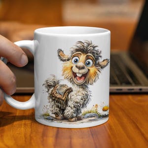 K&ouml;nnte beinhalten: Wei&szlig;e Keramik-Tasse mit einer Cartoon-Lama-Illustration. Das Lama hat ein gro&szlig;es L&auml;cheln, blaue Augen und flauschiges graues und braunes Fell. Es tr&auml;gt einen Sattel. Eine G&auml;nsebl&uuml;mchen befindet sich neben dem Lama. Die Tasse wird von einer Hand gehalten.