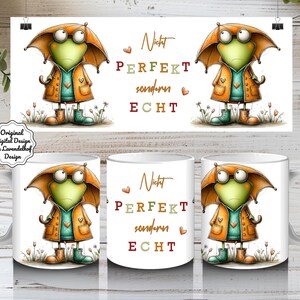 Könnte beinhalten: Weiße Keramik-Tasse mit einer Cartoon-Froschfigur, die einen orangefarbenen Mantel und einen Regenschirm trägt. Der Text "Nicht PERFEKT sondern ECHT" ist auf der Tasse abgebildet. Das Design umfasst kleine Herzen und florale Akzente.