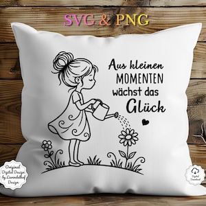 Puede incluir: Coj&iacute;n decorativo blanco con una ilustraci&oacute;n en blanco y negro de una ni&ntilde;a regando una flor. El texto "Aus kleinen Momenten w&auml;chst das Gl&uuml;ck" est&aacute; impreso en el coj&iacute;n. El coj&iacute;n tiene un dise&ntilde;o floral y un coraz&oacute;n.