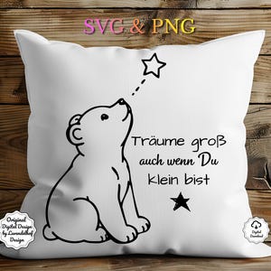 May include: White square pillow with a black and white illustration of a bear looking up at a star. The text "Träume groß auch wenn Du klein bist" is printed on the pillow.