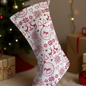 Könnte beinhalten: Ein Weihnachtsstrumpf mit weißem Hintergrund und einem sich wiederholenden Muster aus roten Rentieren, Schneeflocken, Weihnachtsbäumen und Herzmotiven. Der Strumpf hängt vor einem Weihnachtsbaum und Geschenken.
