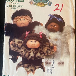 May include: Vintage Butterick pattern for Cabbage Patch Kids clothes. The pattern features three dolls wearing faux fur coats. The cover has the number 21 in red and the text "CLOTHES For your Cabbage Patch Kids!" in black.