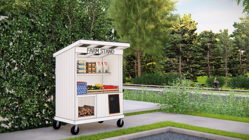 May include: A white mobile farm stand with a black and white striped awning. The stand displays various packaged goods, produce, and firewood. The text "FARM STAND" is printed on the awning. The stand is on wheels and is located outdoors.