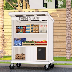 May include: A white farm stand on wheels with the text "FARM STAND" on top. The stand displays various products, including packaged goods, eggs, and fresh produce. A person sits on a chair nearby.
