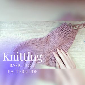 May include: A knitted sock in a dusty rose color. The sock is hand-knitted with visible stitches and a ribbed cuff. Text on the image reads "Knitting BASIC SOCK PATTERN PDF".