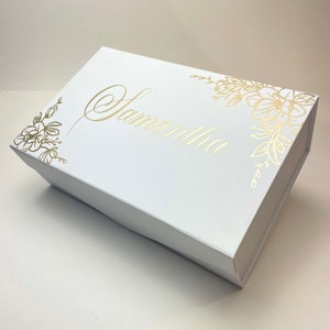 May include: White gift box with a gold floral design and the name "Samantha" written in gold script.