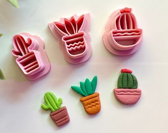 May include: Set of five pink plastic cactus cookie cutters and four fondant cacti in various colors and styles.