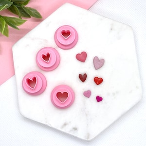 May include: A set of pink heart-shaped cookie cutters and a variety of pink, red, and purple heart-shaped candies.