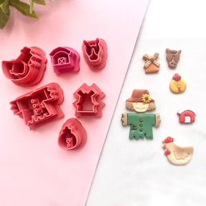 May include: A set of 10 farm-themed cookie cutters and fondant toppers. The cutters are pink and include a barn, chicken, windmill, and more. The toppers are brown, green, and yellow and include a scarecrow, chicken, and windmill.