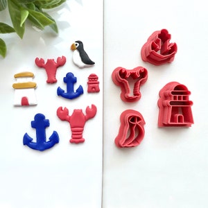 May include: Set of 10 red and blue plastic cookie cutters shaped like a lighthouse, lobster, anchor, and puffin.