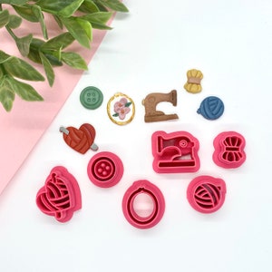 May include: A set of 10 pink and brown plastic cookie cutters shaped like sewing-themed objects, including a sewing machine, buttons, yarn, and a heart with a needle and thread.