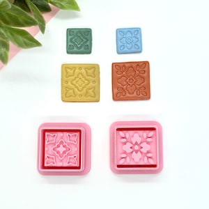 Peut inclure: Ensemble de six tampons en silicone carrés avec différents motifs floraux. Les tampons sont de différentes couleurs, notamment le vert, le bleu, le jaune, l'orange et le rose.