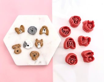 May include: A set of 10 red plastic dog-shaped cookie cutters. The cutters are arranged in two rows on a white surface. The cutters are all different breeds of dogs, including a bulldog, a dachshund, a poodle, and a labrador.