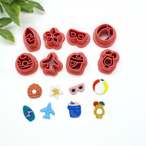 May include: A set of 13 red plastic cookie cutters shaped like various summer-themed objects, including a surfboard, a flower, sunglasses, a beach ball, a bucket, a drink, a plane, and a donut.