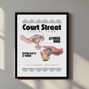 Puede incluir: Impresión enmarcada con una ilustración de cóctel. La obra de arte incluye el texto "Court Street Social Club" y "Athens Ohio". La impresión también indica "Seven Days a Week" y "Low Standards, High Spirits".