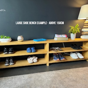 May include: A wooden shoe bench with three shelves, holding various shoes and a few books. The bench is 150cm long and is made by Bolehill Wood Co.