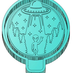 May include: A turquoise blue cookie cutter shaped like a UFO with an alien waving. The UFO is flying over a forest with stars in the sky.