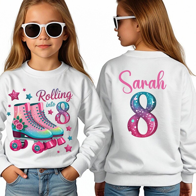 May include: White sweatshirt featuring the text "Rolling into 8" and a pair of colourful roller skates. The number 8 has a galaxy design. The back of the sweatshirt has the name "Sarah" and a galaxy-themed number 8.